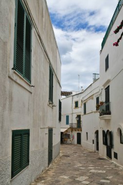 A narrow street among the old houses in the historic center of Otranto, a town in Puglia in Italy.