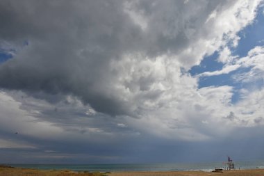 Stormy clouds over a sandy beach of Salento in Italy.