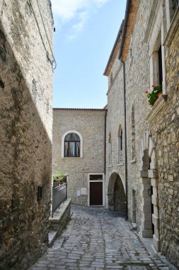 A narrow street between the old houses of Pietragalla, a village in the Basilicata region, Italy.