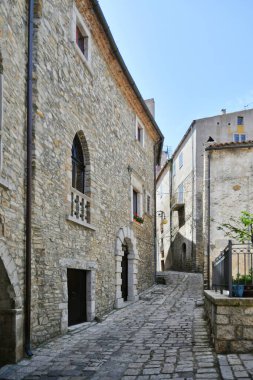 A narrow street between the old houses of Pietragalla, a village in the Basilicata region, Italy.