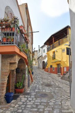 A narrow street between the old houses of Grottole, a village in the Basilicata region, Italy.