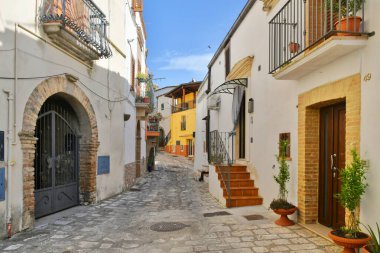 A narrow street between the old houses of Grottole, a village in the Basilicata region, Italy.