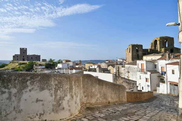 A narrow street between the old houses of Grottole, a village in the Basilicata region, Italy.