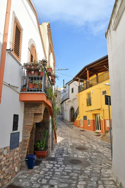 A narrow street between the old houses of Grottole, a village in the Basilicata region, Italy.