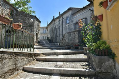 A narrow street among the old houses of Greci, a village in the Campania region, Italy.