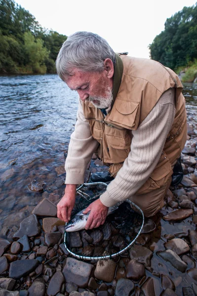 Fisherman removing hook — Stock Photo, Image