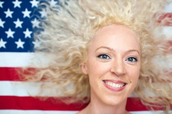 Ganska vilda hår kvinna på amerikanska flaggan Stockfoto
