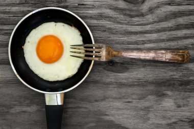 sahanda yumurta ve ahşap zemin üzerine çatal