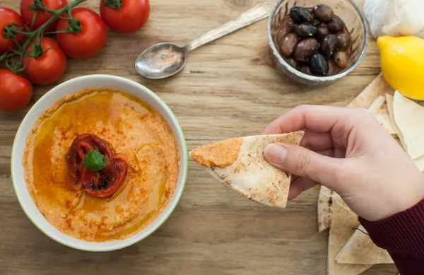 Sumergiendo pan de pita en hummus — Foto de Stock