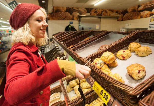 Young woman buying scones at bakery — Stock Photo, Image