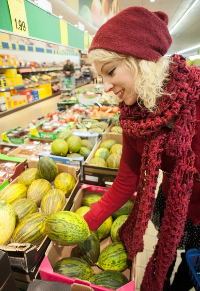 Pretty female customer buying melon Royalty Free Stock Images