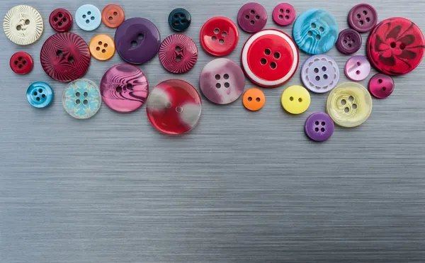 Sewing buttons on brushed metal background — Stock Photo, Image