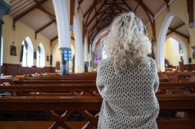 Woman praying in church from behind clipart