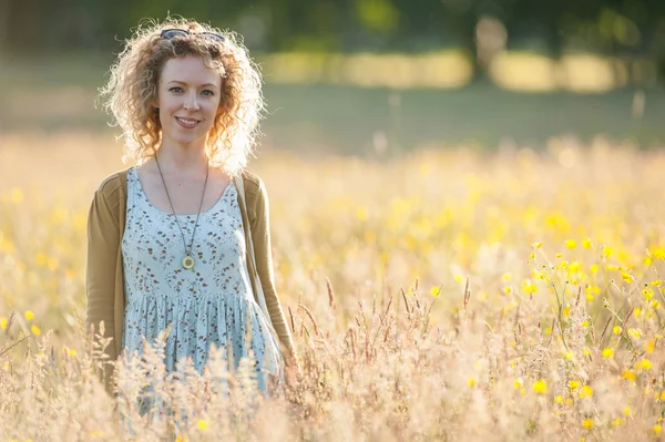 年轻快乐的女人站在一片草地 — 图库照片