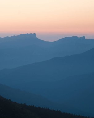 Gün batımı ışığında dağ silueti katmanları. Doğanın güzel fotoğrafçılığı, mavi katmanlı arka plan. Doğal eğilim.