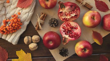 Elma, nar, tarçın, koni, ceviz, ahşap zemine düşmüş yapraklar. Sonbahar bileşimi.