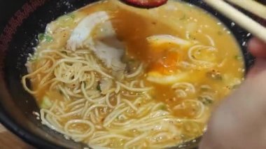 Yumurta, domuz eti ve soğanlı makarna kasesi. Susam tohumlu garnitür ramen. Üst Manzara. Asya mutfağı