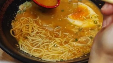 Yumurta, domuz eti ve soğanlı makarna kasesi. Susam tohumlu garnitür ramen. Üst Manzara. Asya mutfağı
