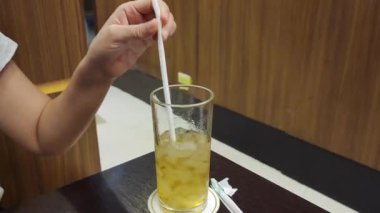 Ahşap masada pipetli buzlu yeşil çay.