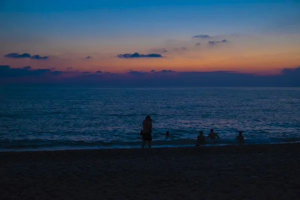 Bir deniz plaj güneş battıktan sonra yıkananlara