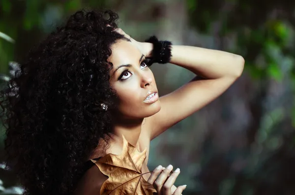 Portrait of a young black woman in the park with a dry leaf — Stock Photo, Image