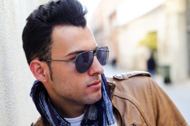yakışıklı bir genç adam, kentsel arka planda peruğu ile moda model portresi