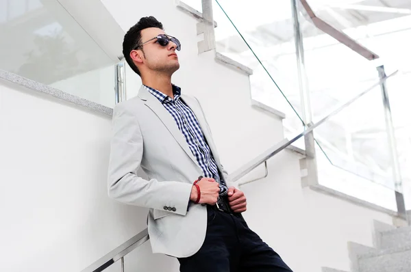 Retrato de un joven guapo, modelo de moda, con gafas de sol teñidas — Foto de Stock