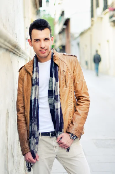 Egy jóképű fiatalember, a divat, a városi háttérben hajcsomó modell-portré — Stock Fotó