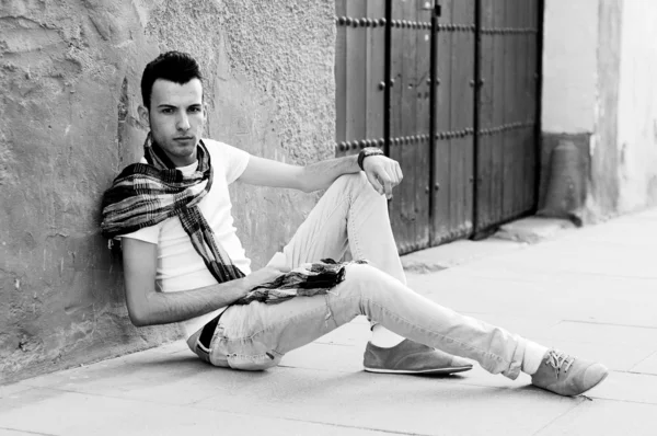 Retrato de un joven guapo, modelo de moda, con peluquín en el fondo urbano — Foto de Stock