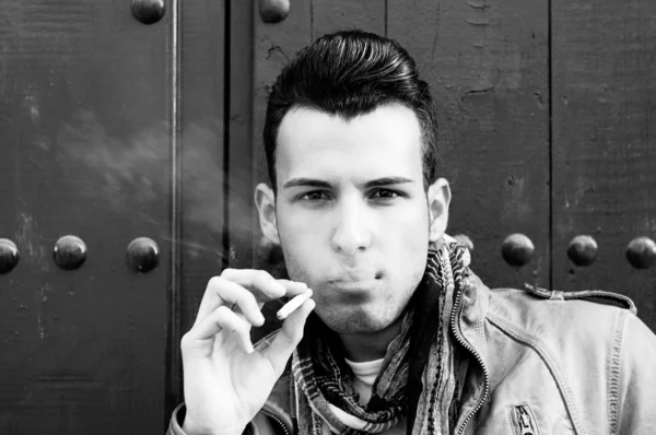 Portrait of an attractive young man smoking cigarette — Stock Photo, Image