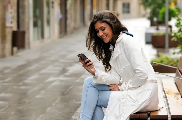 Retrato de una hermosa joven en el fondo urbano hablando por teléfono — Foto de Stock