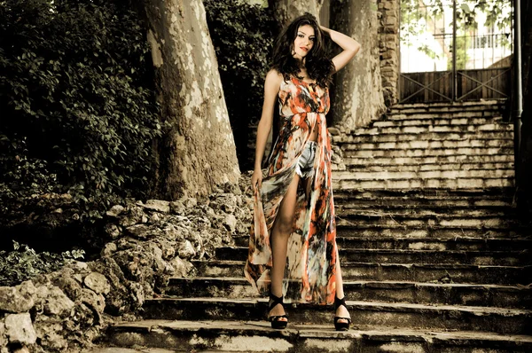 Beautiful young woman, model of fashion, in a garden stairs — Stock Photo, Image