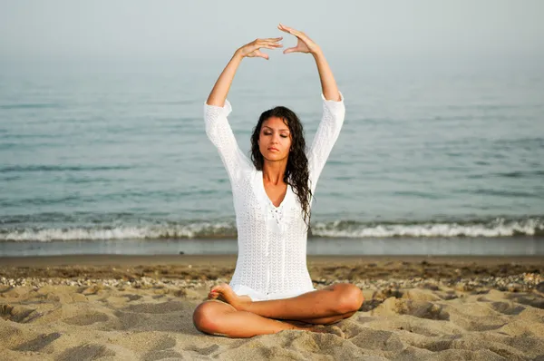 Pretty woman doing yoga on the beach — Stock Photo, Image