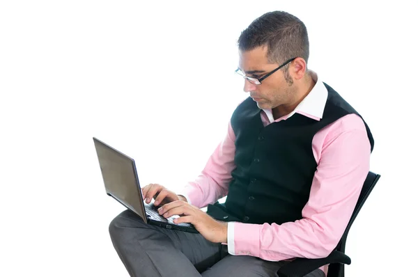 Uomo d'affari di successo che indossa giubbotto e camicia rosa guardando un piccolo computer — Foto Stock