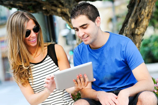 Atractiva pareja con tableta en el fondo urbano — Foto de Stock