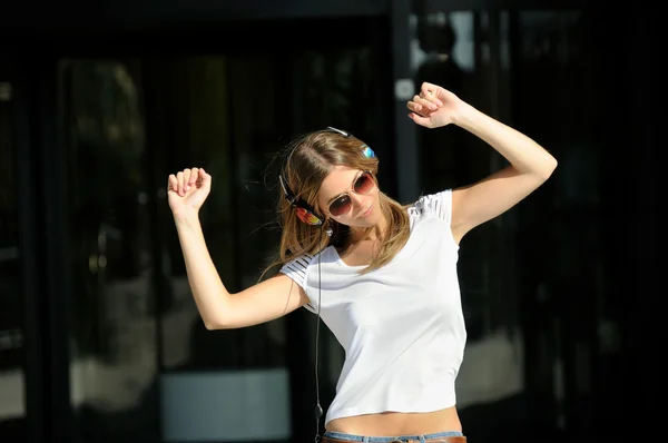 Chica joven con auriculares en la calle —  Fotos de Stock