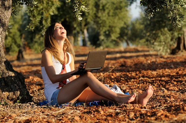 Ragazza con un computer portatile in un campo in autunno — Foto Stock