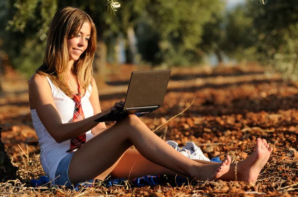 Mädchen mit Laptop im Herbst auf einem Feld — Stockfoto