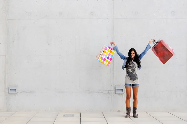 Rapariga atraente com sacos de compras na rua — Fotografia de Stock