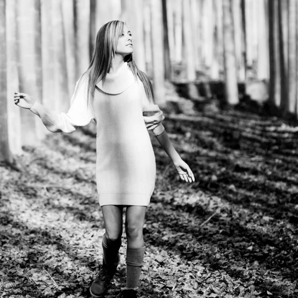 Beautiful blonde girl, dressed with a beige dress, standing in a — Stock Photo, Image