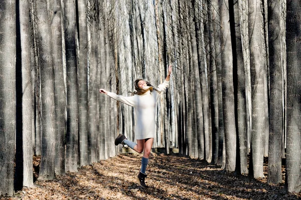 Menina loira bonita, vestida com vestido bege, saltando em th — Fotografia de Stock