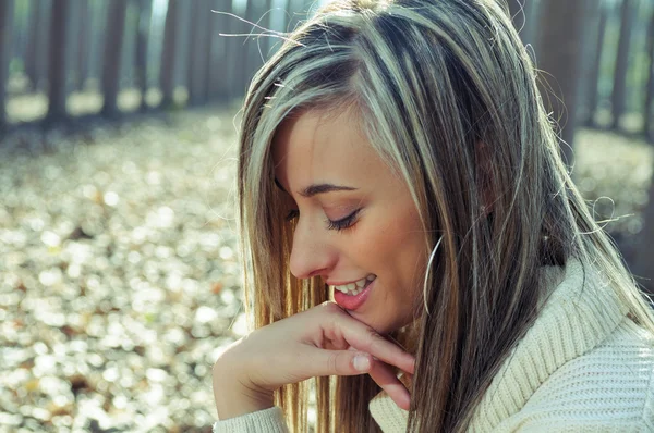 Belle fille blonde, vêtue d'une robe beige, debout dans une — Photo