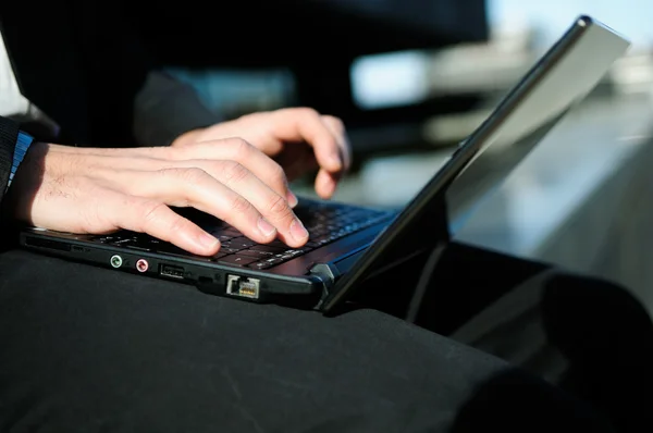 Händerna på en affärsman som skriver med en bärbar dator — Stockfoto