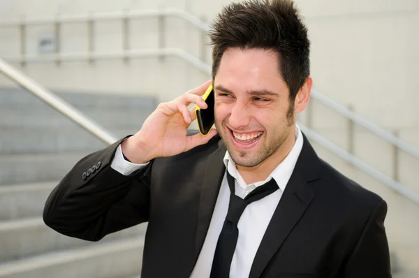 Aantrekkelijke man in stedelijke achtergrond praten over telefoon — Stockfoto