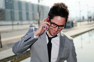 Portrait of handsome man in urban background talking on phone