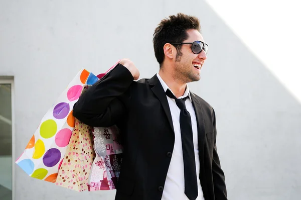 Retrato de um jovem bonito com sacos de compras — Fotografia de Stock