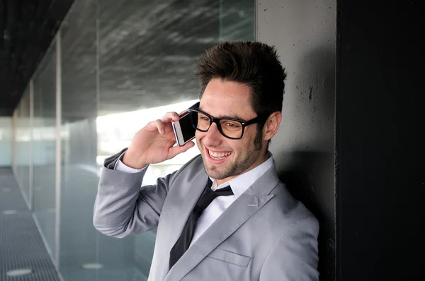 Portrait of handsome man in urban background talking on phone — Stockfoto