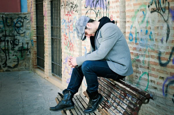 Retrato de hombre guapo en el fondo urbano con una gorra retro — Foto de Stock