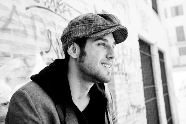 Retrato de hombre guapo en el fondo urbano con una gorra retro —  Fotos de Stock