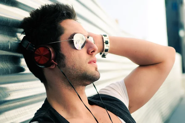 Portrait of handsome man in urban background listening to the mu — Stock Photo, Image